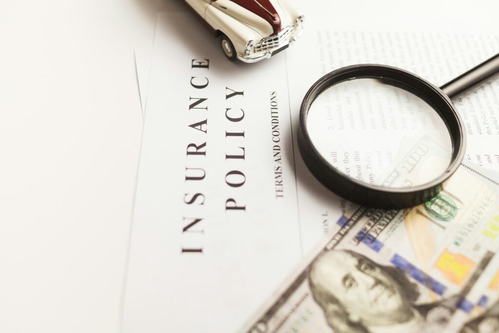Insurance policy document with a magnifying glass and cash