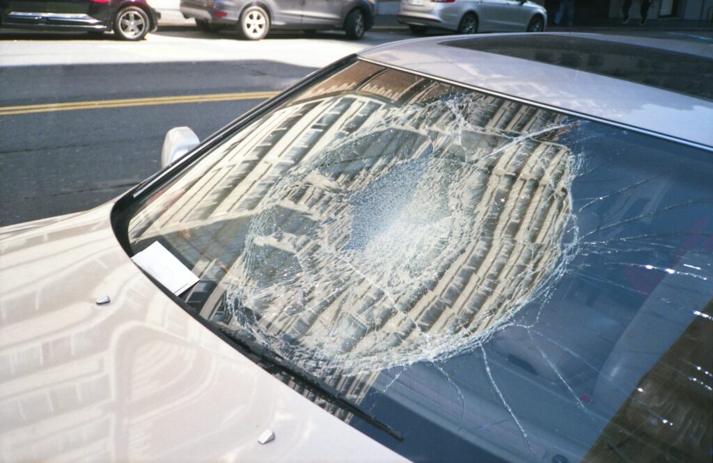 Car windshield shattered into a spiderweb of cracks after a collision