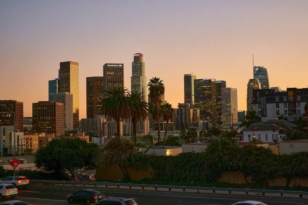 Downtown Los Angeles skyline at sunset above a freeway