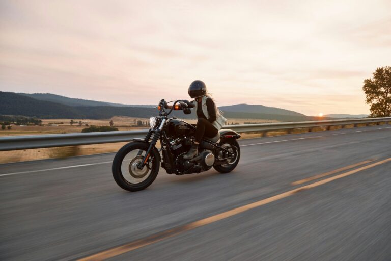 Motorcyclist riding along an open highway at sunset
