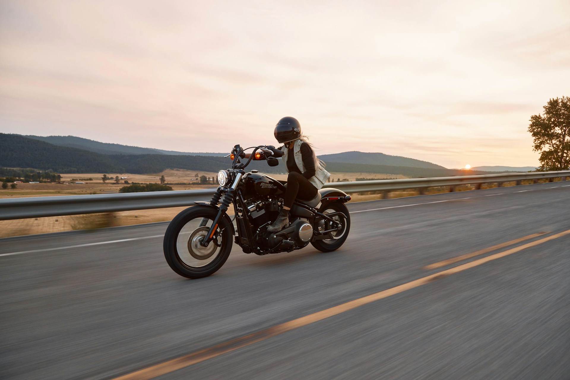 Motociclista en una carretera abierta al atardecer
