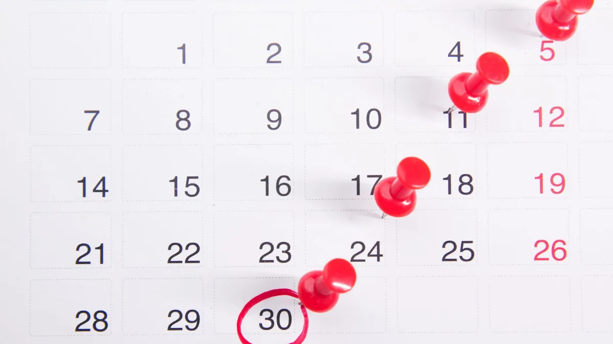 Red pins marking several important dates on a calendar