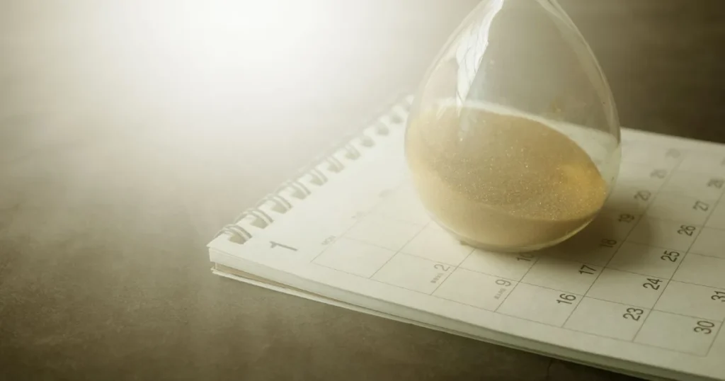 An hourglass resting on a calendar, representing a legal filing deadline