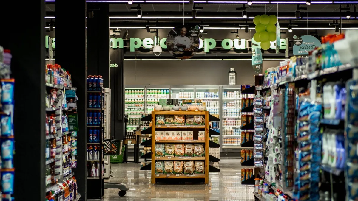 An empty, well-lit grocery store aisle with stocked shelves