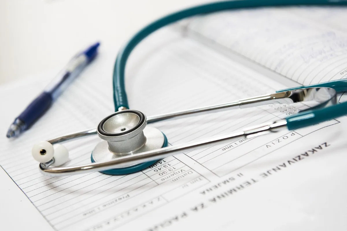Stethoscope and pen resting on a printed medical report on a desk
