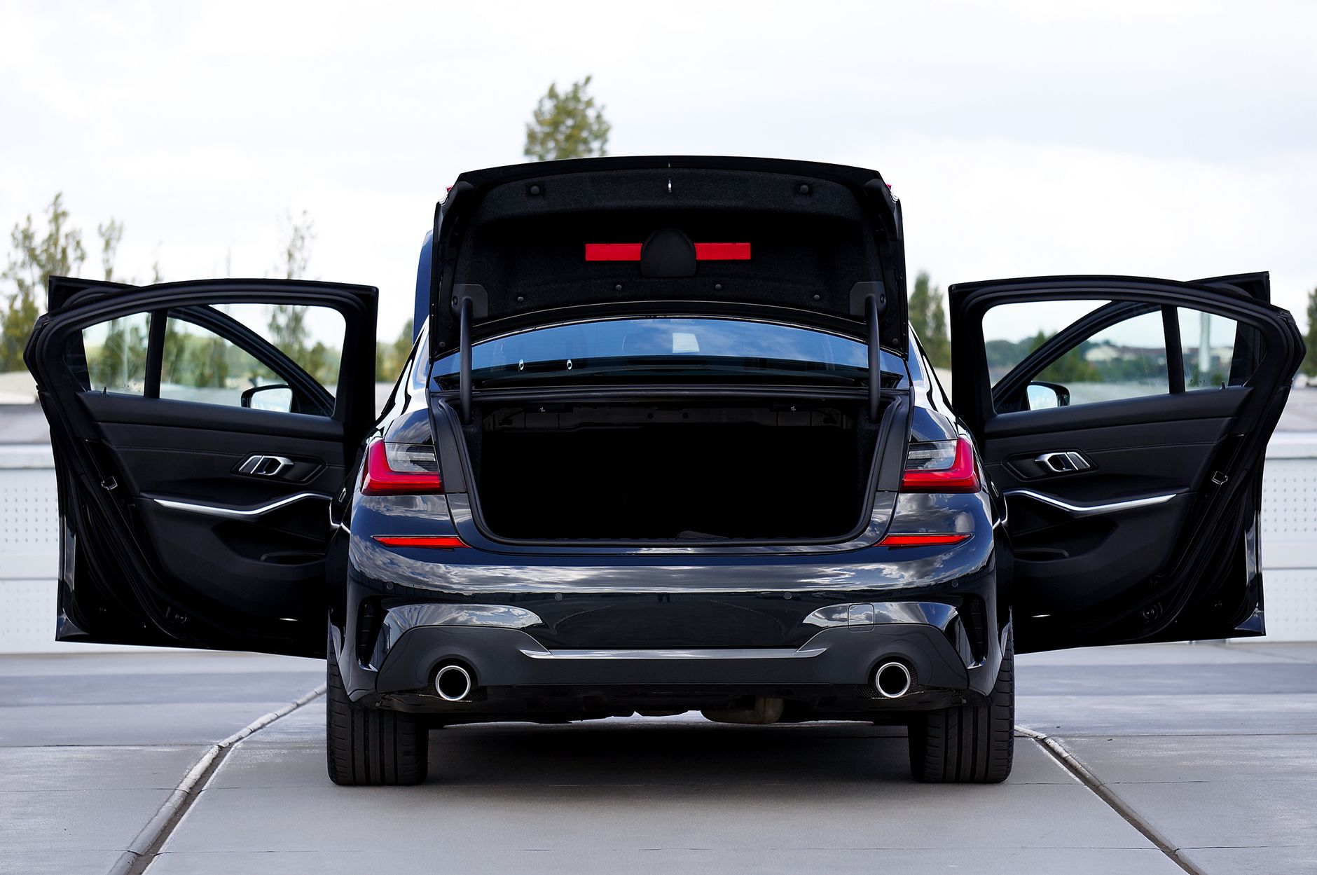 Rear passenger door of a black limousine standing open at the curb