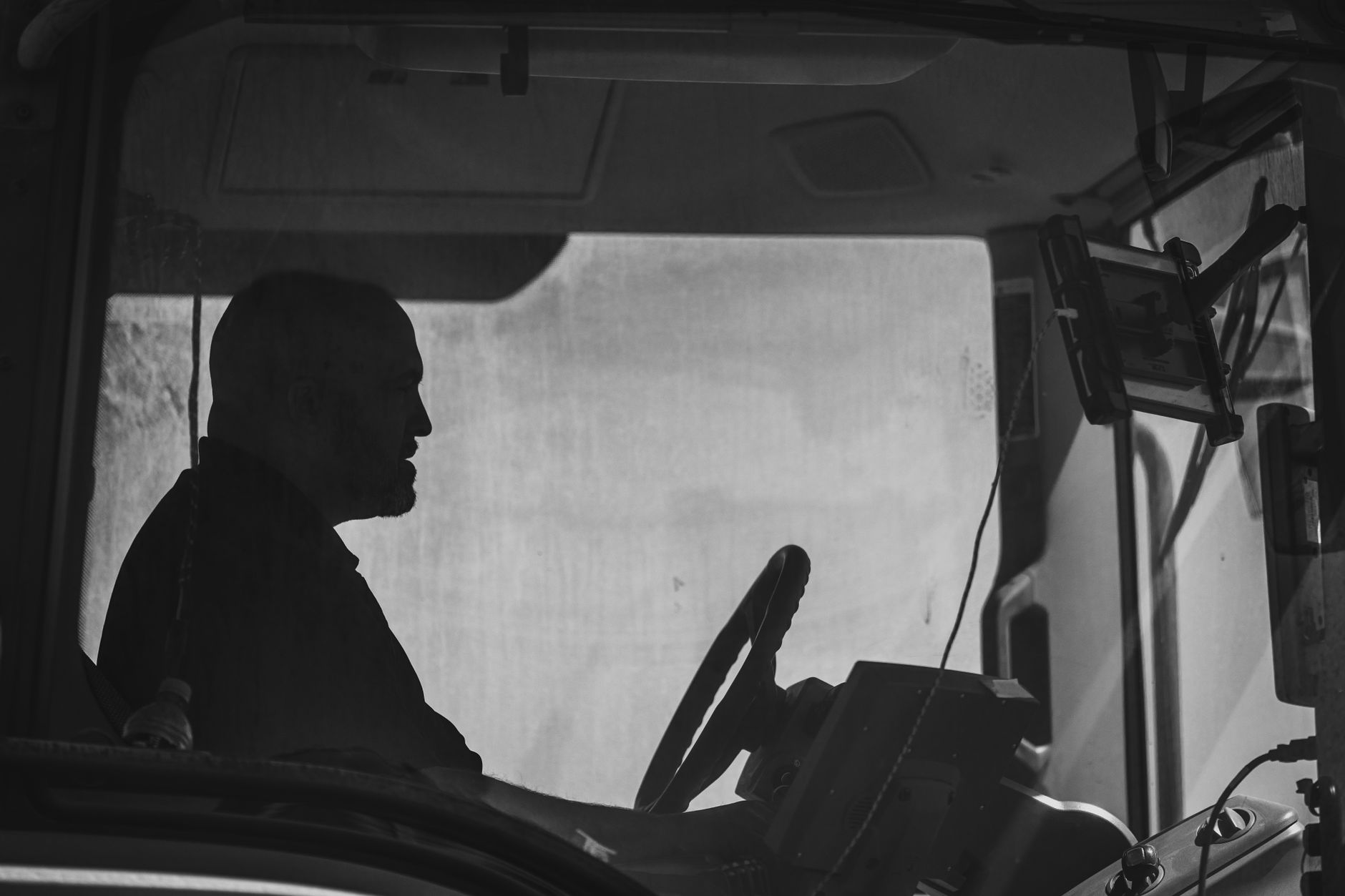 A commercial truck driver's cab with an electronic logging tablet mounted on the dashboard