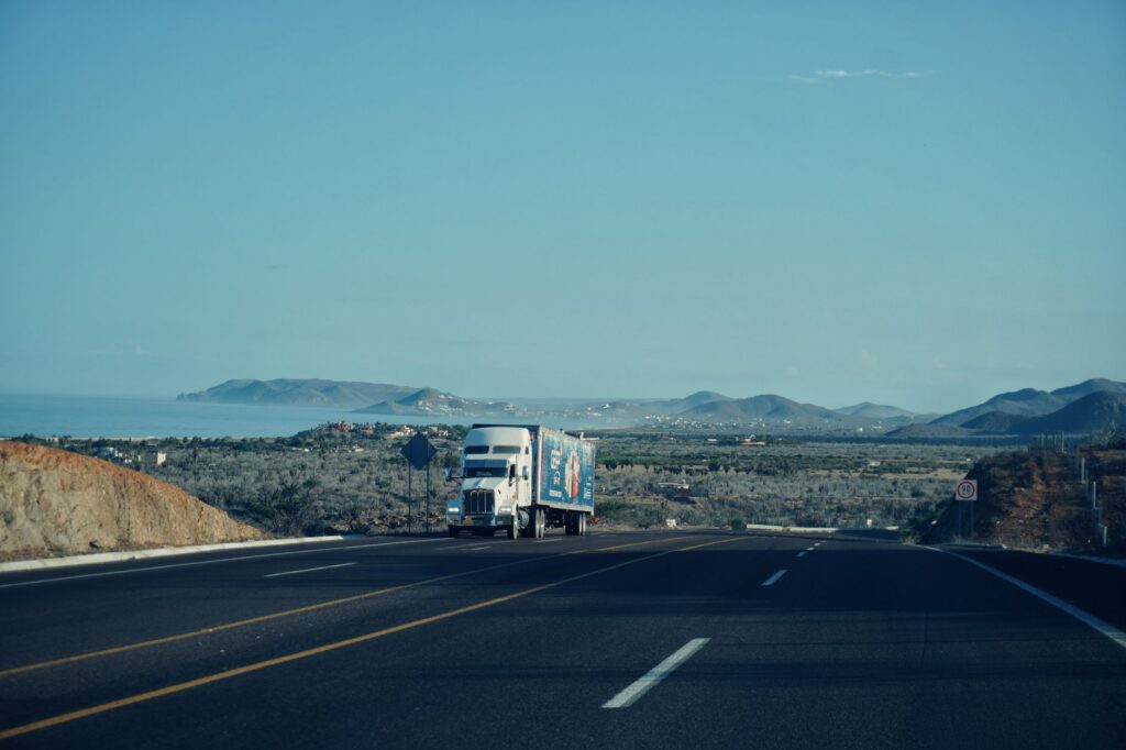 A tractor-trailer traveling on a multi-lane California freeway in daylight