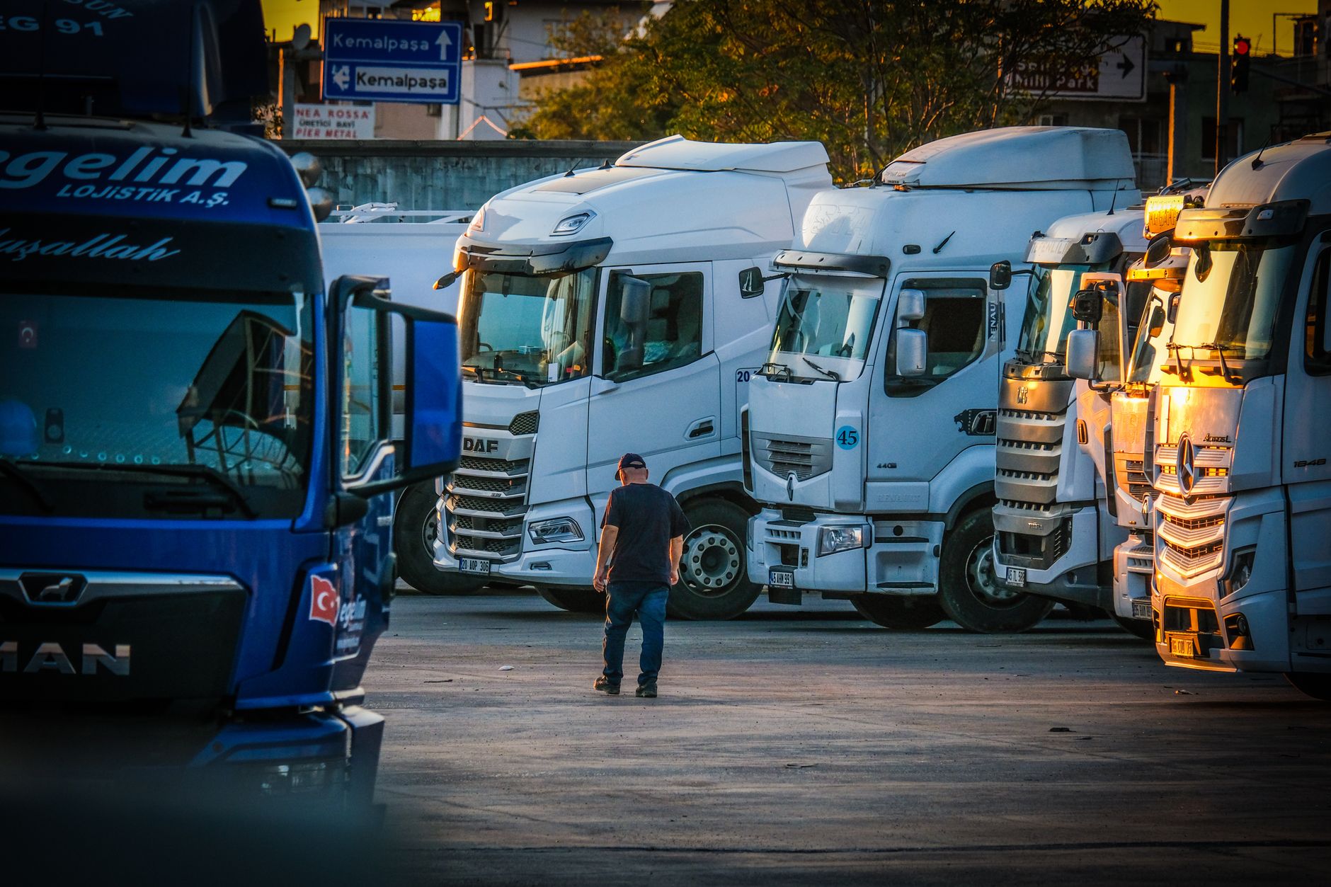 Tractor-trailers parked in a truck stop lot after dark