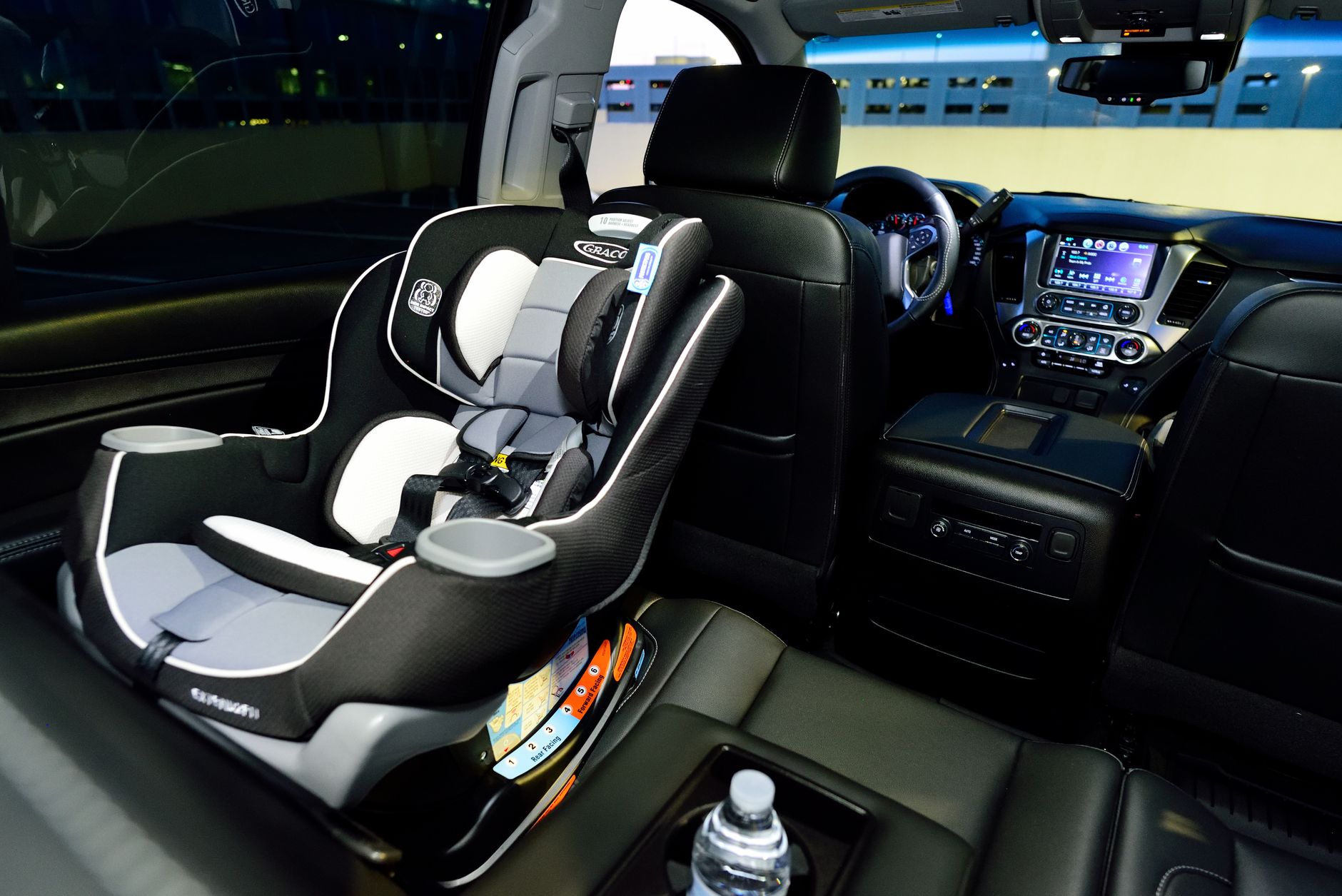 A rear-facing infant car seat installed in the rear seat of a car