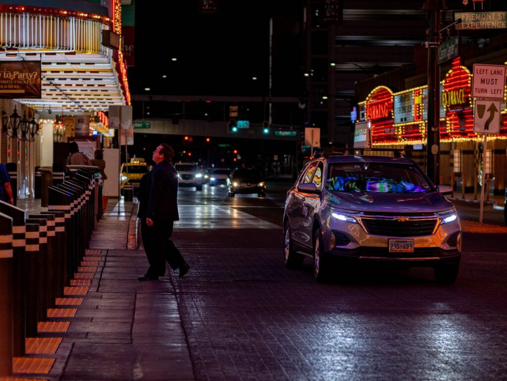 A marked police cruiser parked on a Las Vegas street at night with emergency lights on