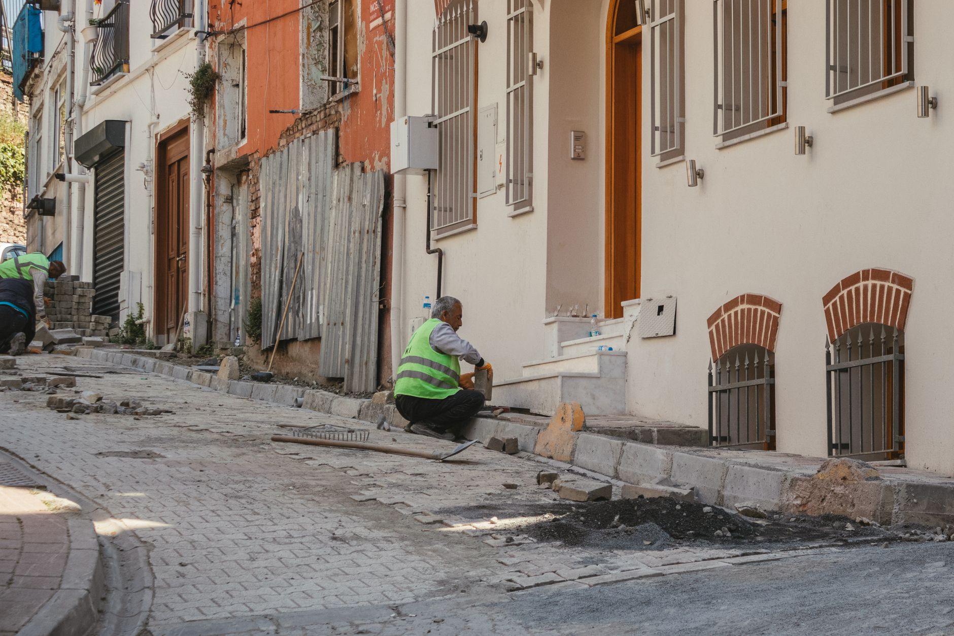 A public works employee examining a damaged section of sidewalk before repair