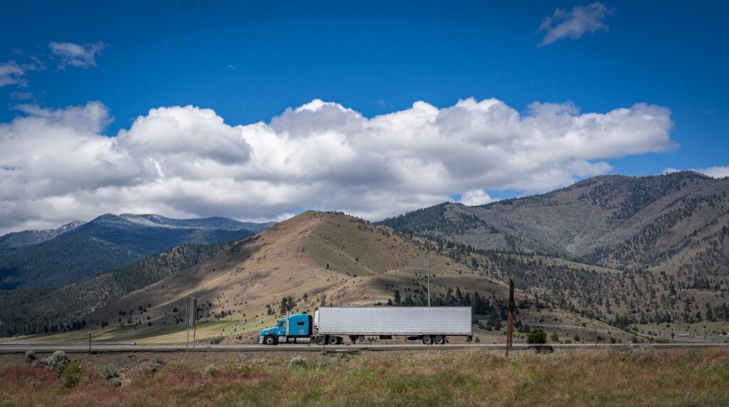 A loaded tractor-trailer traveling on a California freeway in daylight