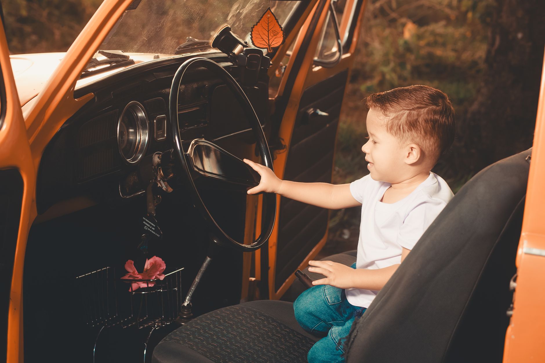A young child secured in a harnessed car seat with the chest clip fastened