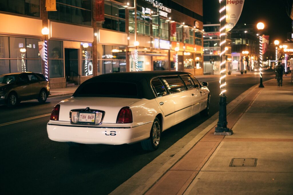 A white stretch limousine parked on a city street at night in California