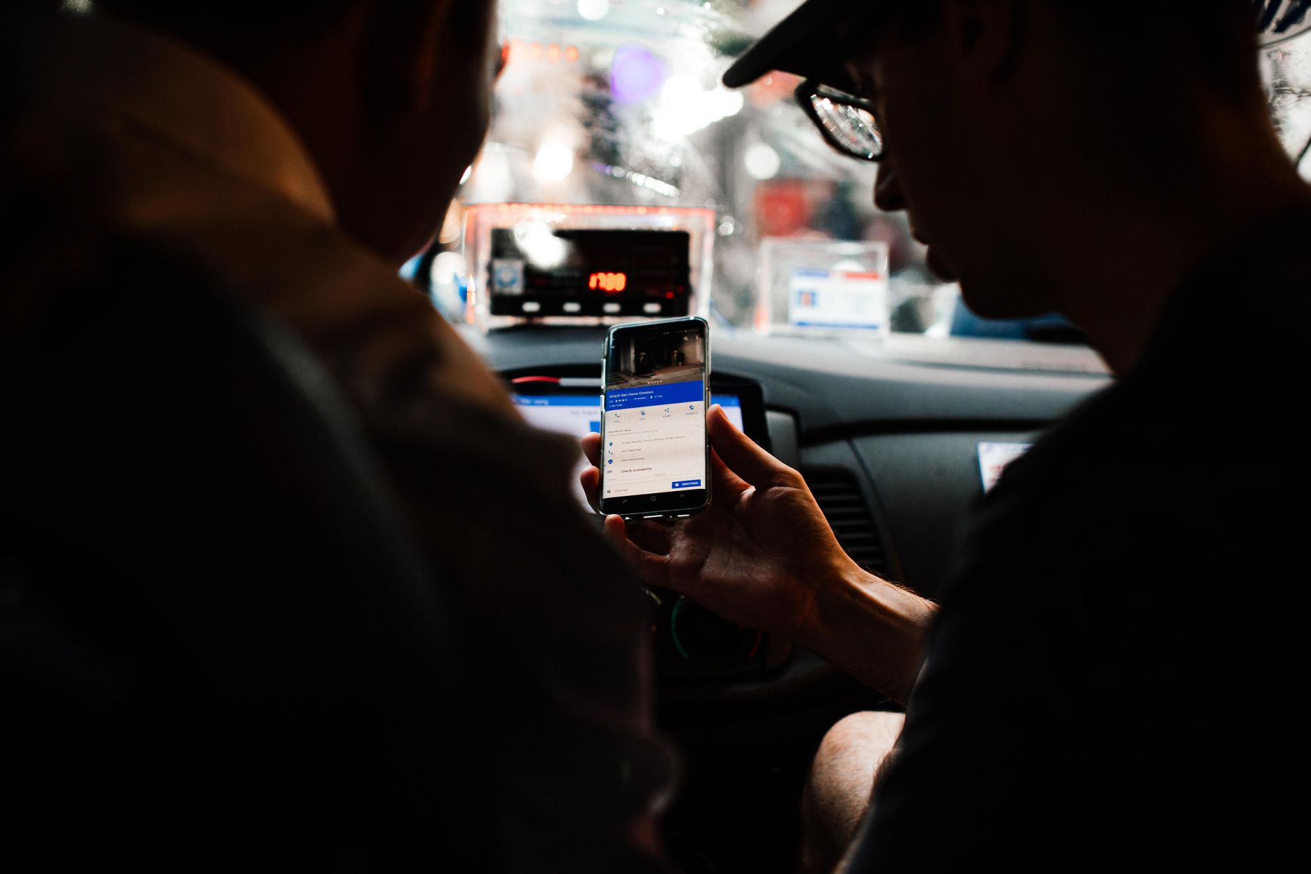 A passenger seated in the back of a rideshare vehicle on a city street