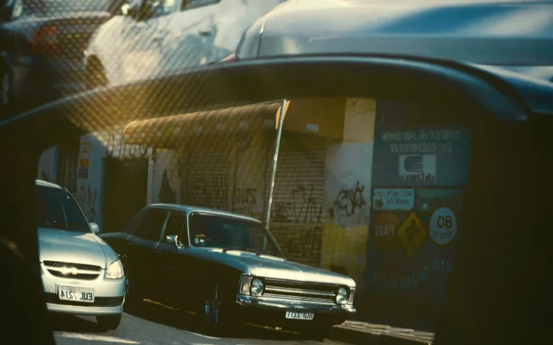 Close-up of a car's side view mirror reflecting traffic in the next lane