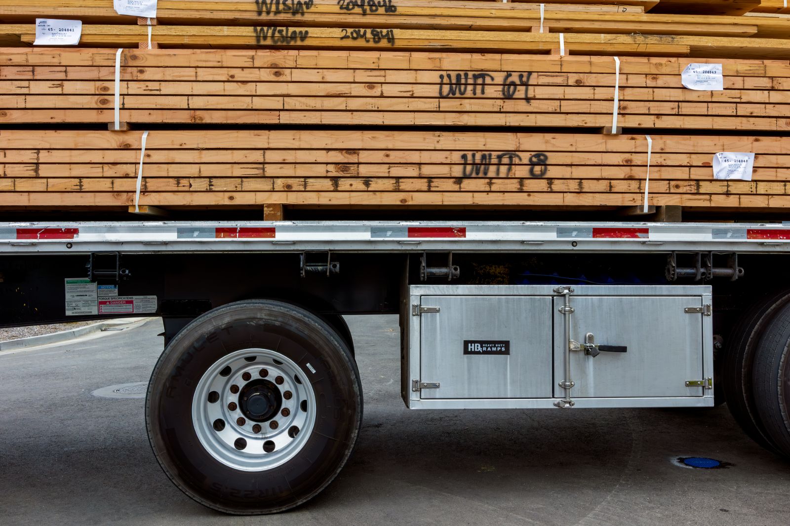Freight on a flatbed trailer held down by ratchet straps and chains