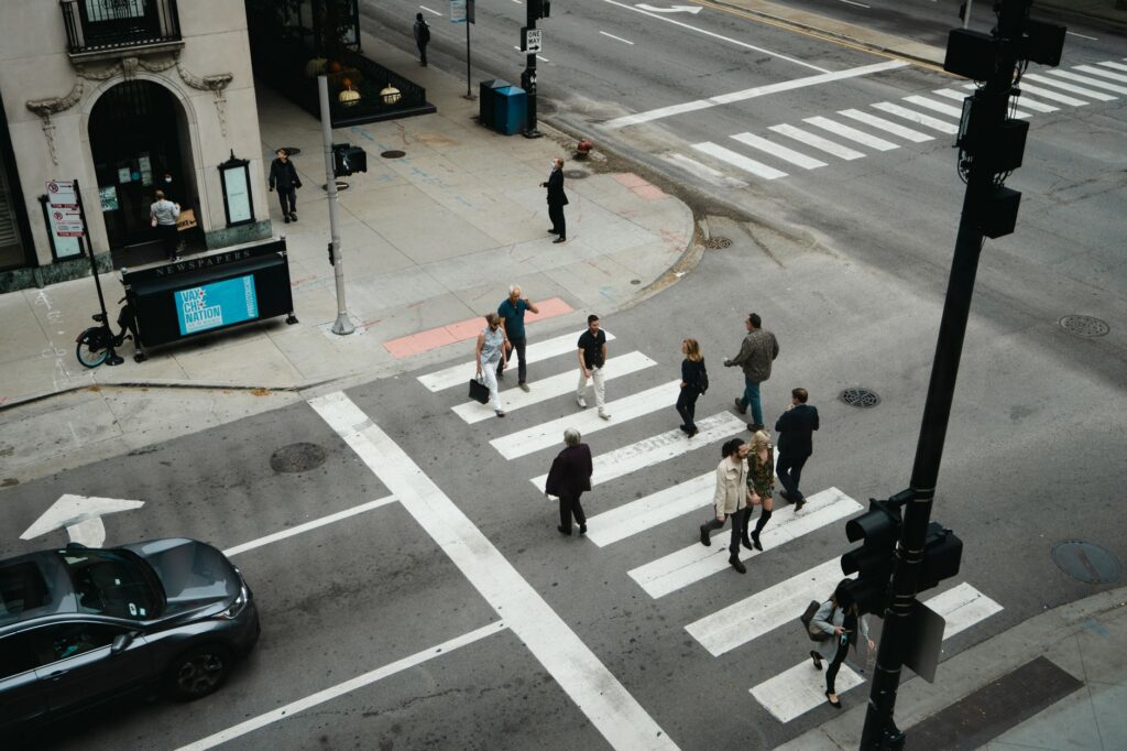 A pedestrian crossing a city street in a marked crosswalk