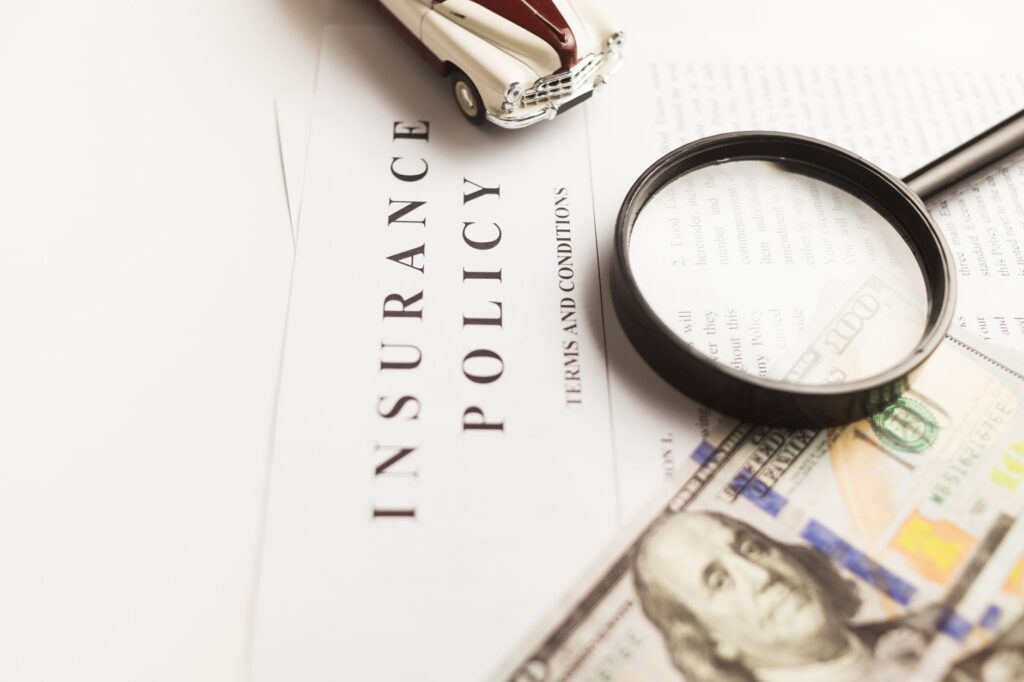 An insurance policy document examined with a magnifying glass