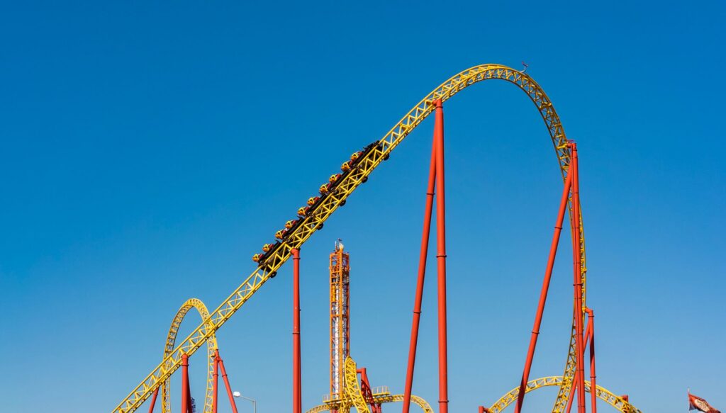 Roller coaster track against a clear blue sky at an amusement park