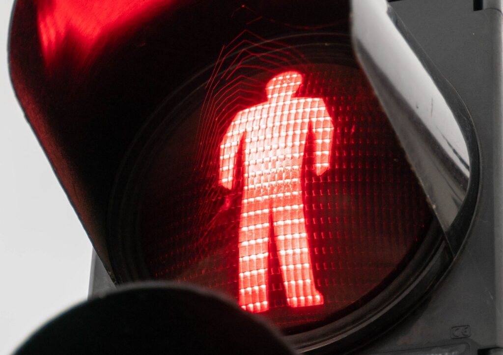 A signal-controlled city intersection with pedestrians waiting to cross