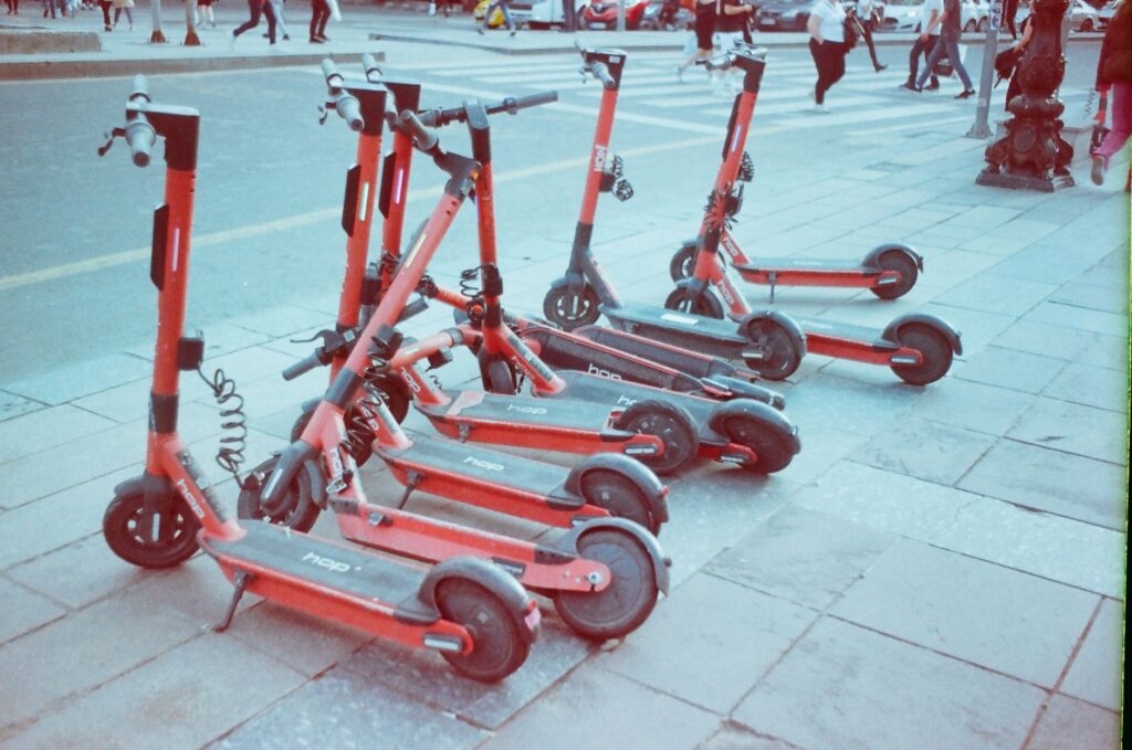 Shared electric scooters parked along a city sidewalk