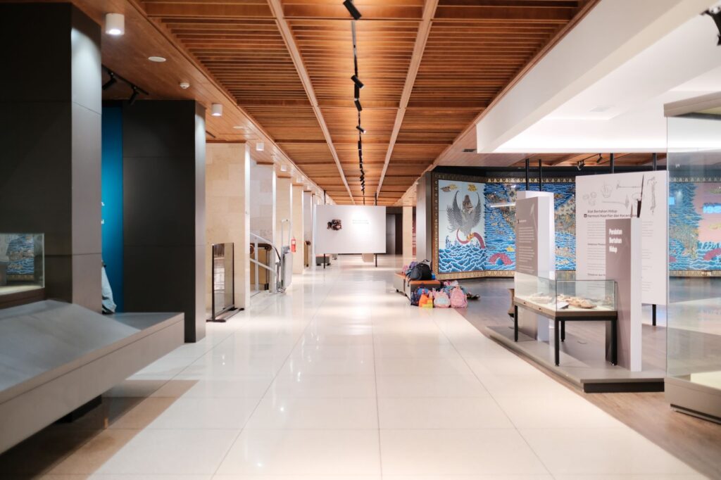 Wide interior hall of a modern museum with exhibits and no visible faces