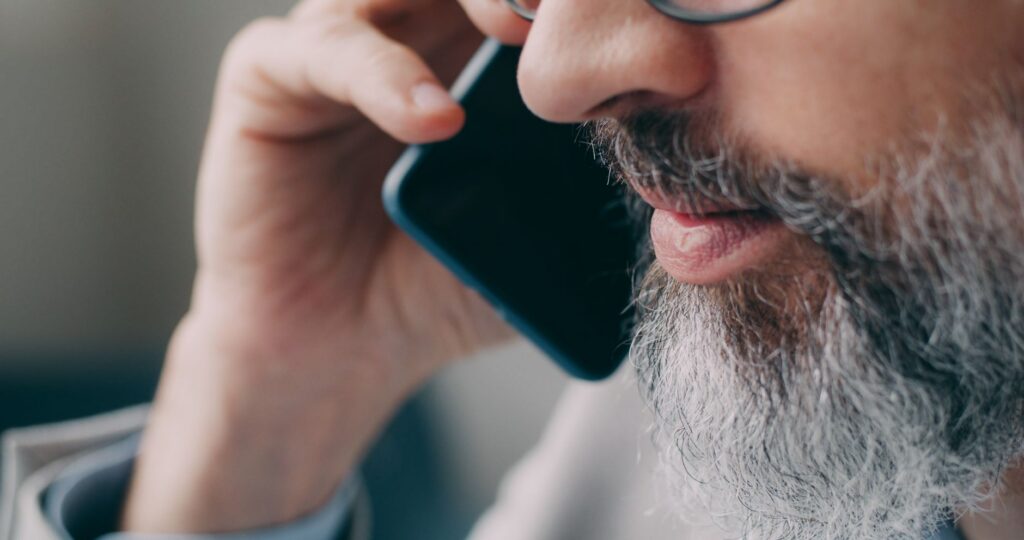 A man speaking on the phone indoors