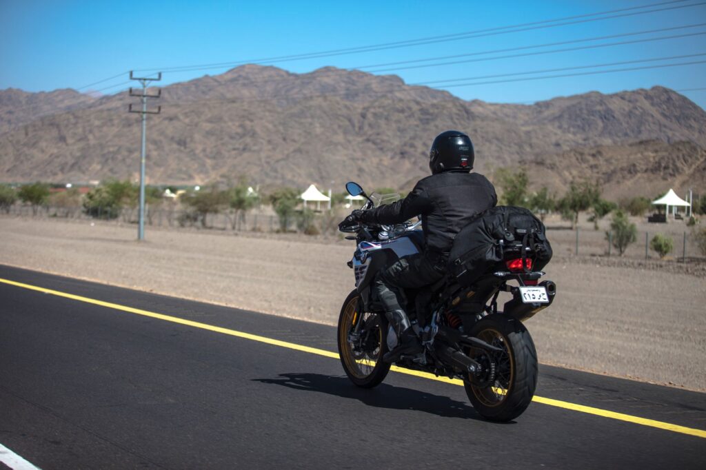 A motorcyclist riding along an open desert highway