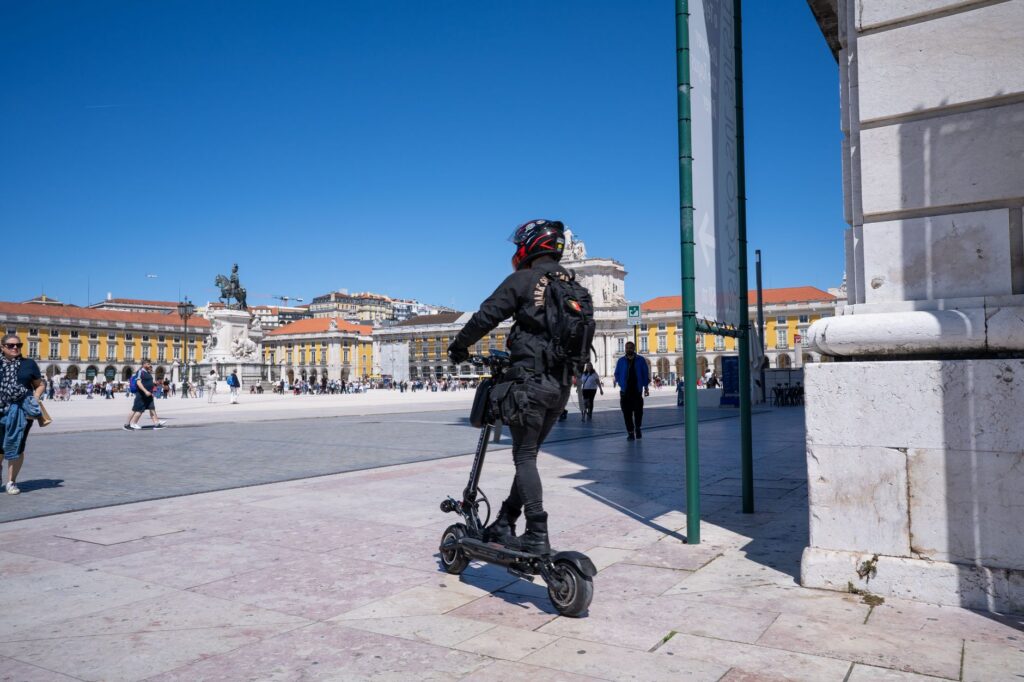 A rider on an electric scooter traveling along a city street