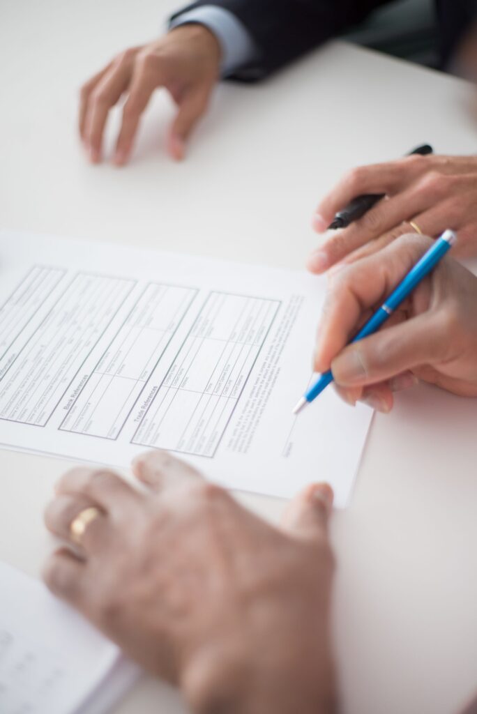 Hands signing a written agreement on a desk
