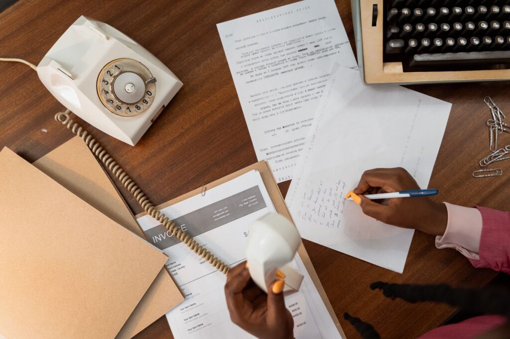A demand package being prepared at a desk with documents and a pen