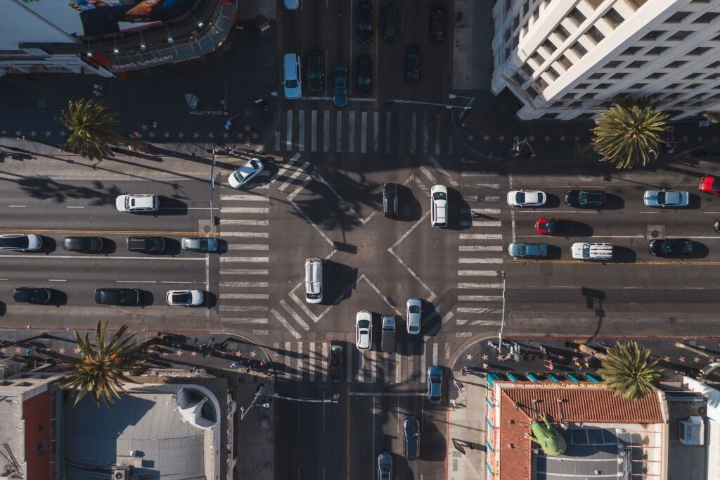 Aerial view of a wide multi-lane intersection with crosswalks and heavy traffic