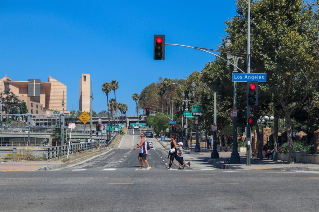 Pedestrians crossing a wide city street in a marked crosswalk at a signalized intersection
